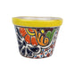 Yellow rim ceramic planter with orange flowers, deep blue petals, golden-orange scrollwork, and a red-and-blue dotted lattice pattern.