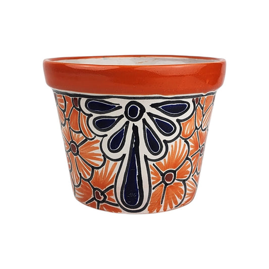 Red orange rim ceramic planter with orange flowers, burgundy centers, and a large deep blue teardrop floral motif on a white background.