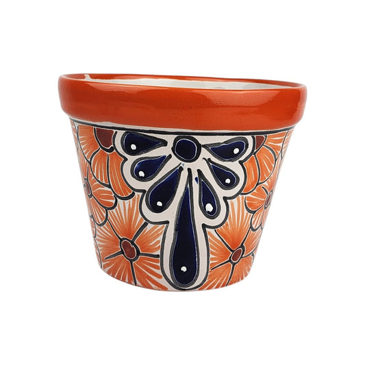 Red orange rim ceramic planter with orange flowers, burgundy centers, and a deep blue teardrop motif accented with white dots and black outlines.
