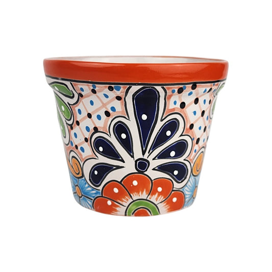 Red orange rim ceramic planter with deep blue and orange floral motifs, green accents, and peach lattice lines with blue and black dots.
