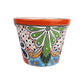 Red orange rim ceramic planter with green teardrop artwork, blue flowers, golden-orange scrolls, and peach lattice with blue and black dots.
