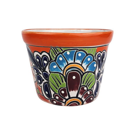 Red orange rim ceramic planter with sky blue and burgundy flowers, deep blue petals, green leaves, and white dotted highlights.
