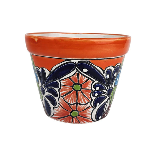 Red orange rim ceramic planter with orange flowers, green centers, deep blue petal and teardrop motifs, white dots, and black outlines.
