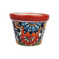 Red rim ceramic planter with red and sky blue flowers, deep blue accents, orange scrollwork, and green details on a white background.