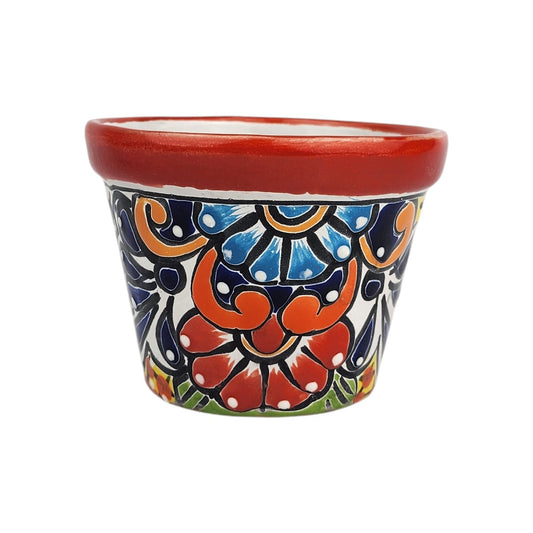 Red rim ceramic planter with red and sky blue flowers, deep blue accents, orange scrollwork, and green details on a white background.