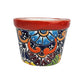 Red rim ceramic planter with sky blue and burgundy flowers, orange scrollwork, deep blue accents, and green leaves on a white background.
