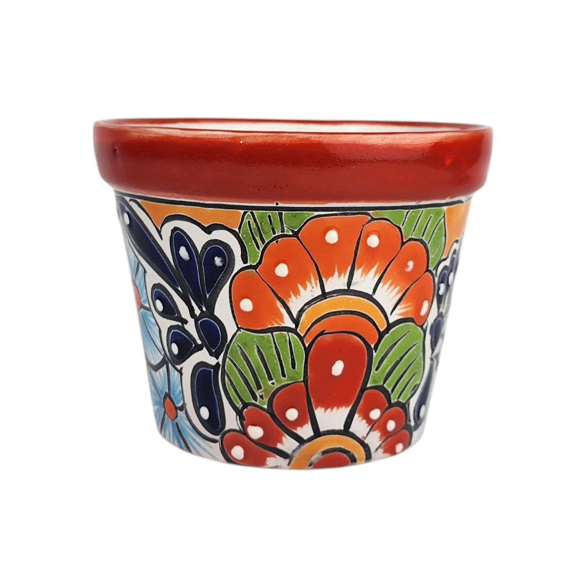 Red rim ceramic planter with large orange and red flowers, green leaves, deep blue petals, and white dotted highlights on a white background.
