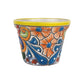 Yellow rim ceramic planter with orange flowers, blue centers, sweeping blue teardrop motifs, and green accents on a white background.