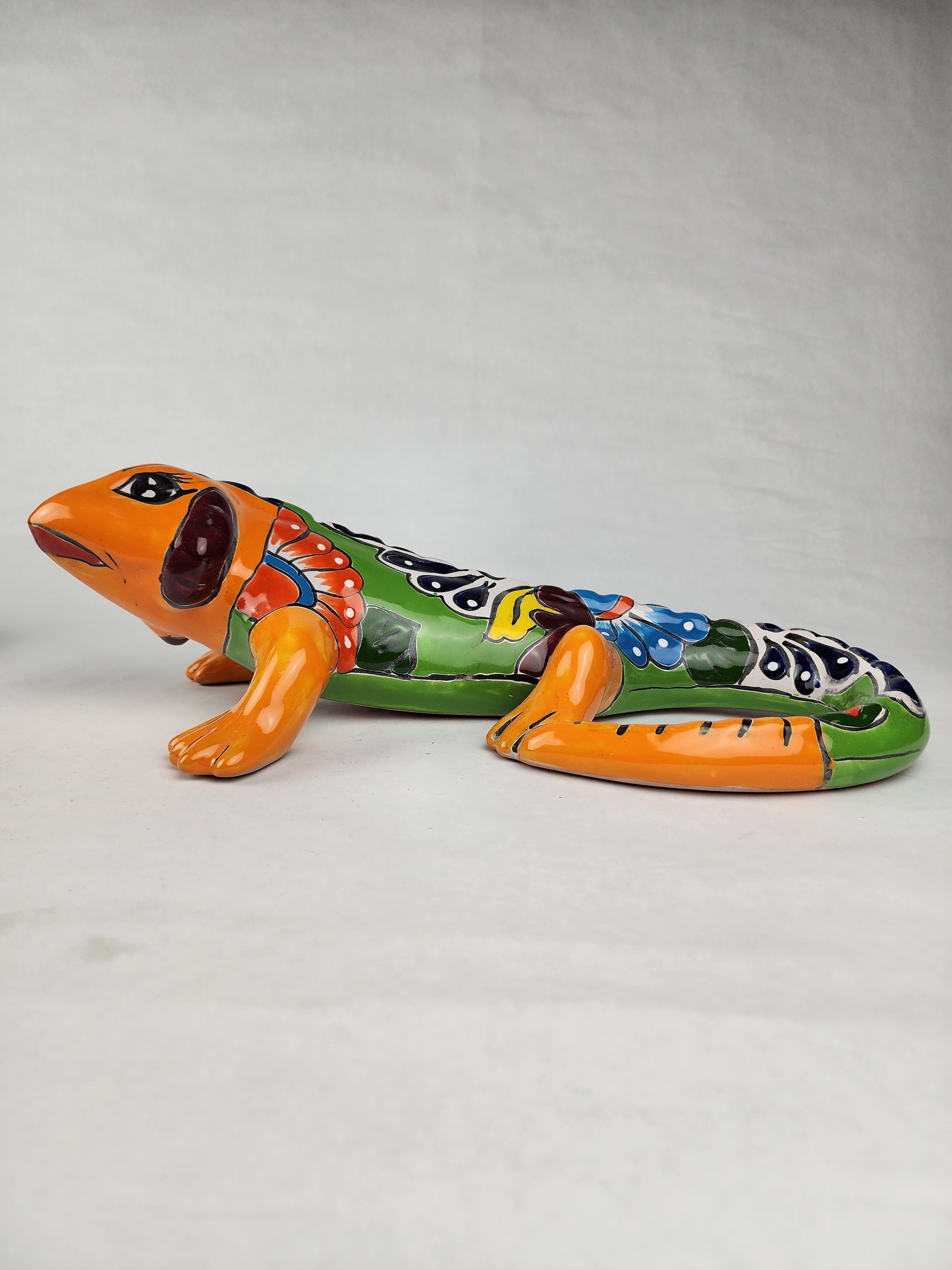 Video of a colorful Talavera-style ceramic gecko figurine featuring hand-painted floral-inspired patterns and a glossy Mexican folk art finish.